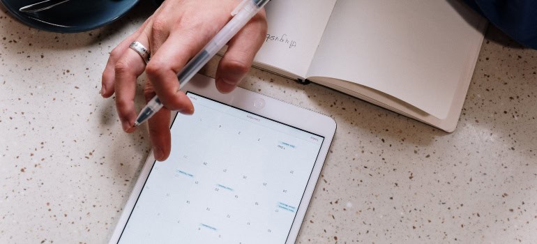 A person inserting tasks into a schedule on a tablet screen.