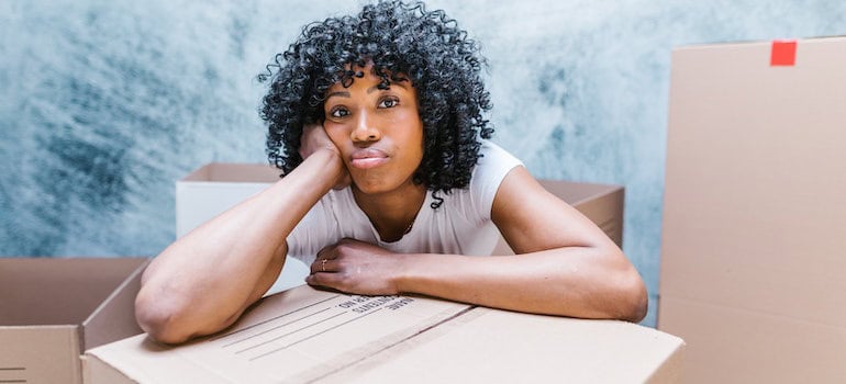 A woman thinking about indicators you may need professional moving help