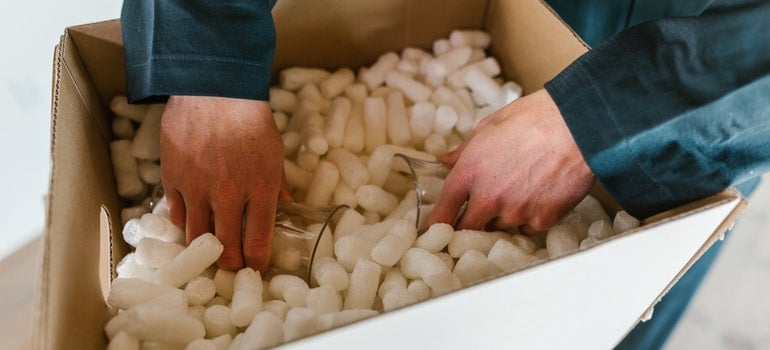 man packing glass item