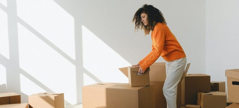 A woman carrying moving boxes