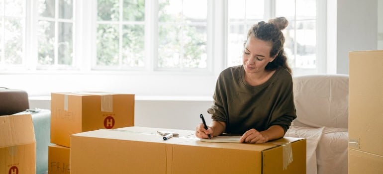 a girl writing a list before packing antique furniture for your VA relocation