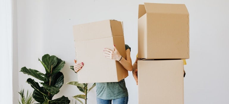 A couple holding moving boxes