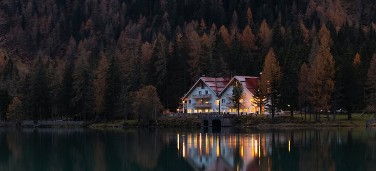 waterfront home behind pine trees