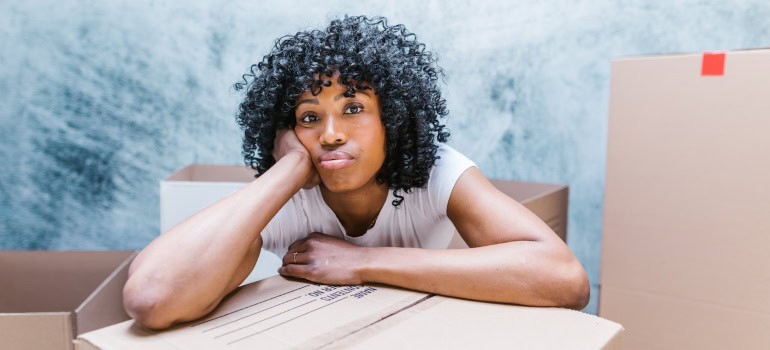 a woman leaning on a cardboard box