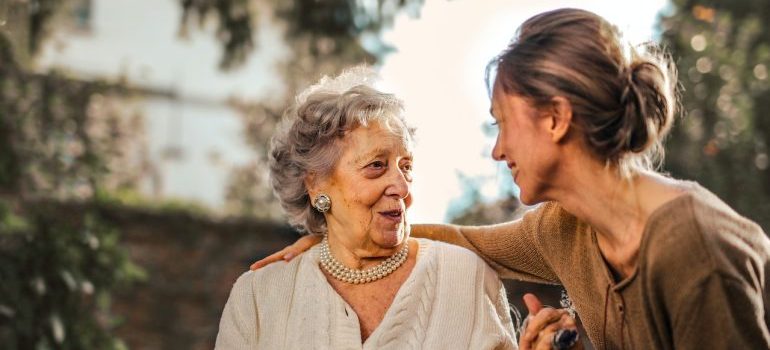 A younger woman talking to an older woman about senior move management