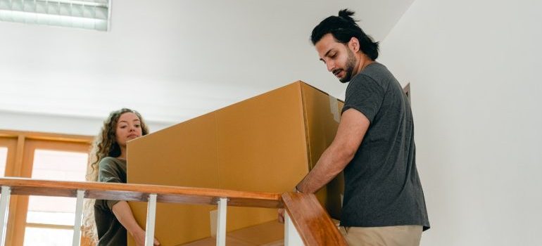 A couple moving to Northern Virginia and carrying boxes