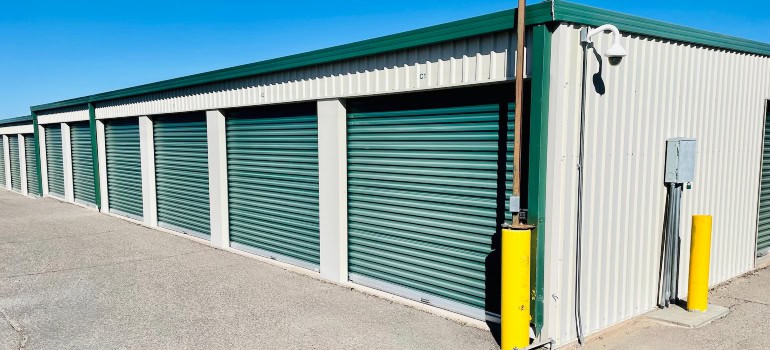 A row of self-storage units with green doors.