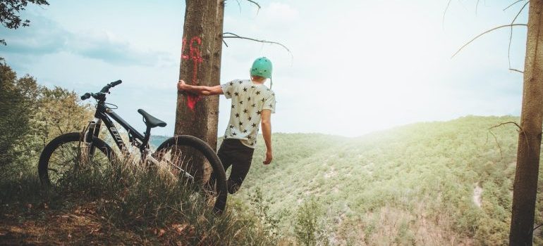 man holding a tree near bike