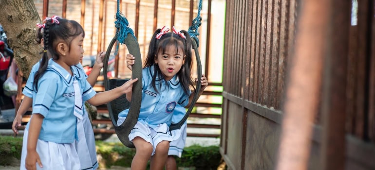 little girls sitting on a swing