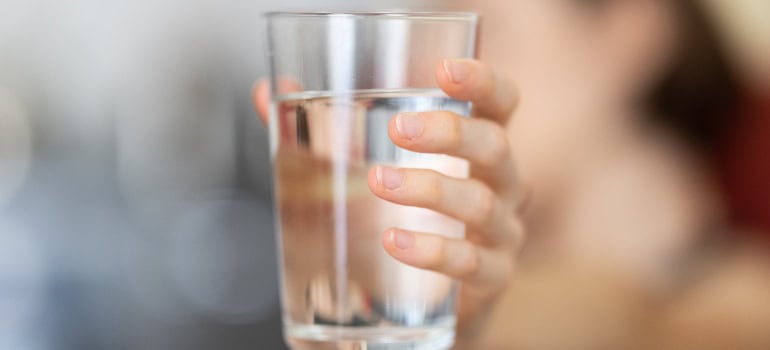 a glass of water which is necessary to cope with hot weather during a summer family move