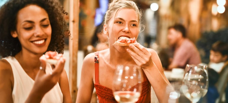 Two friends eating and drinking in a nice restaurant.