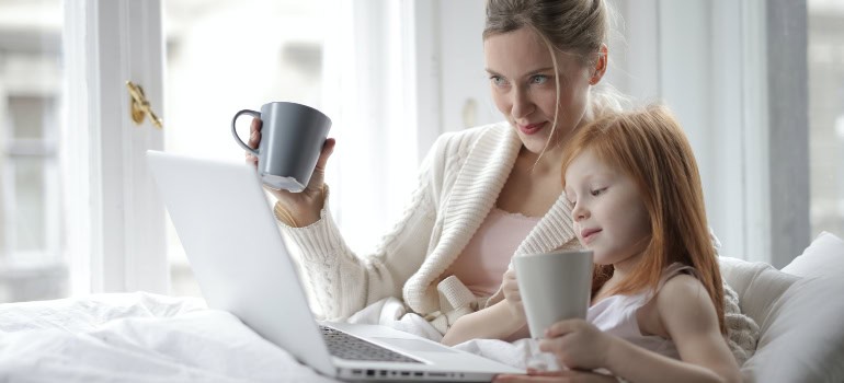 A woman and a little girl talking to someone via a laptop