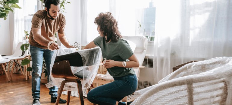 two people arranging and unpacking furniture together