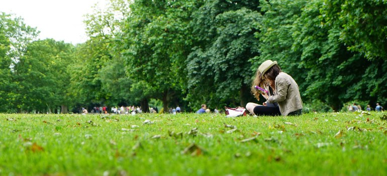 a person sitting on healthy-looking grass in a park