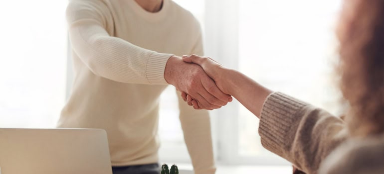 two people shaking hands when one of them was hired after moving from Annandale to Lorton