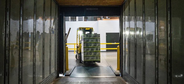 a person loading boxes into a truck by using a forklift