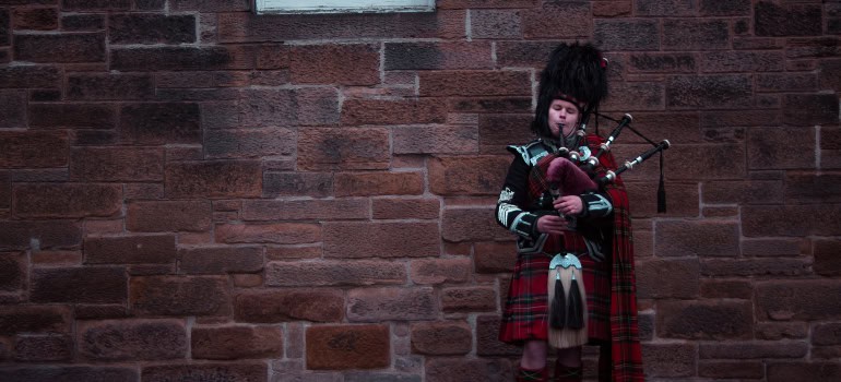 a man playing bagpipes while wearing a kilt