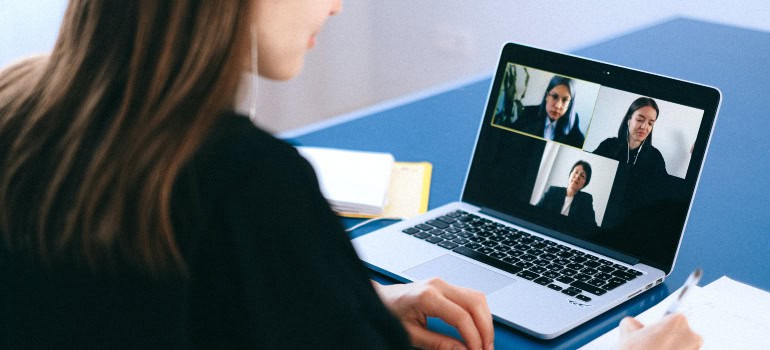 a woman attending a video conference and explaining to colleagues what is a hybrid office design