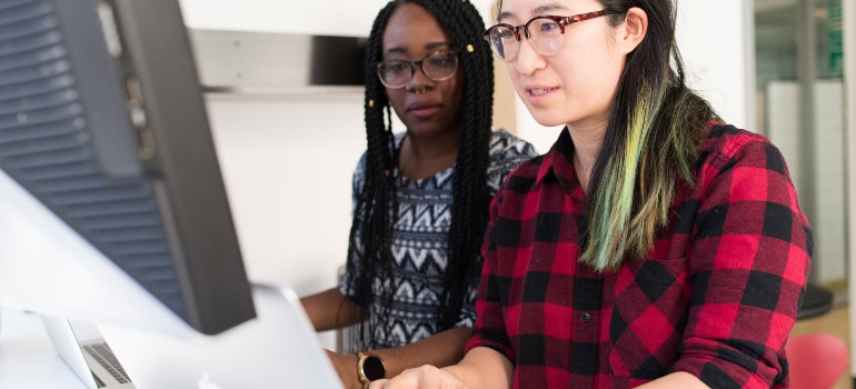 two women working on a computer and effectively applying the best practices for managing office inventory and supplies