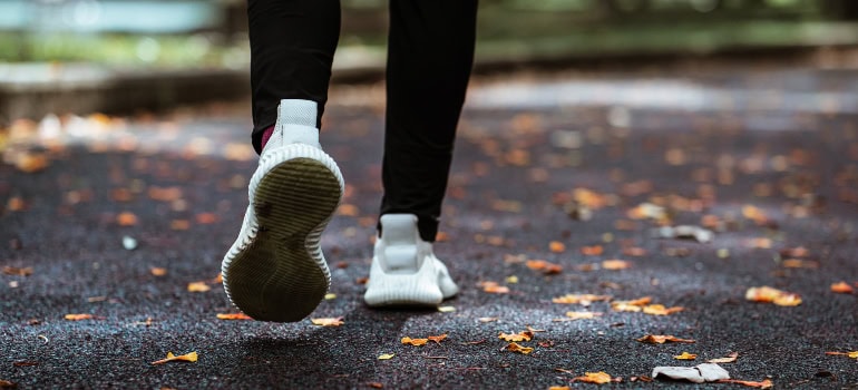 a person in white sneakers walking along the path in the park