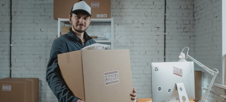 a moving specialist holding a large cardboard box