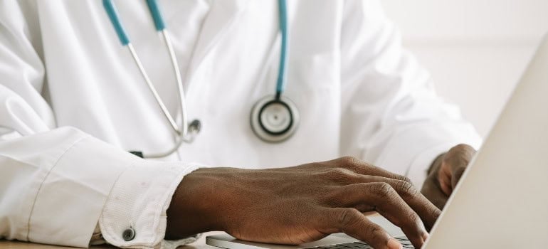 a doctor working on his computer after moving from Alexandria to Woodbridge