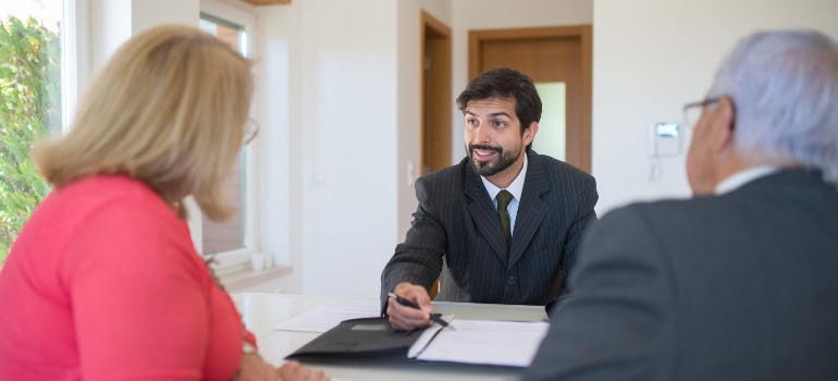 a real estate agent explaining something to a couple