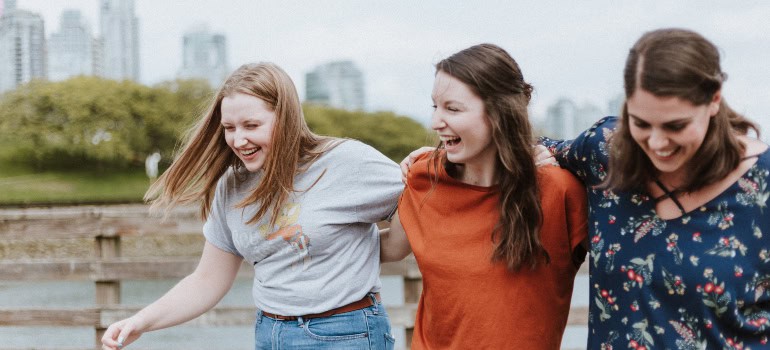 three friends laughing and supporting each other 