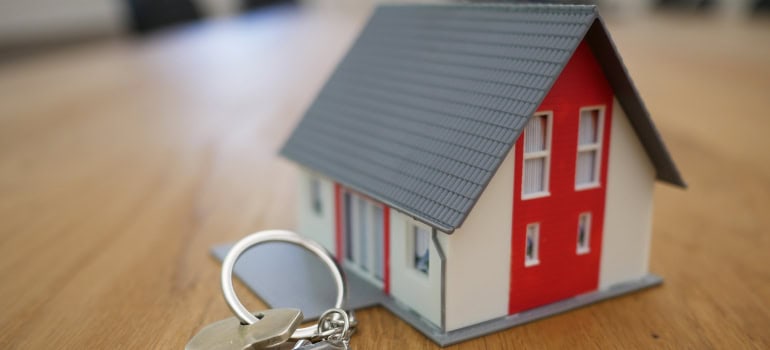 a model of a house and a house key next to it