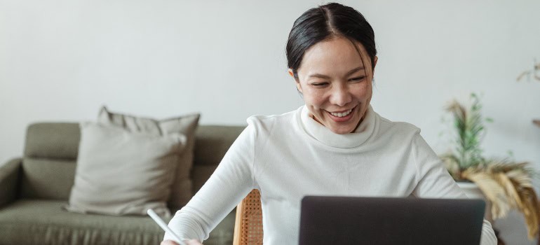 a woman doing research on a laptop regarding moving to Chantilly on a budget