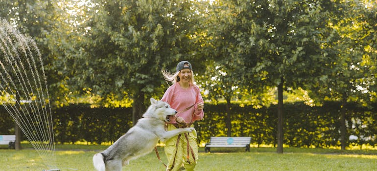 a woman playing with her dog in the park