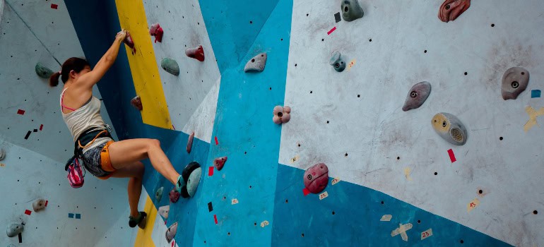 a woman doing rock climbing on an artificial rock