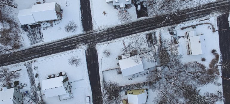 a road in a city covered in snow, with no traffic on it