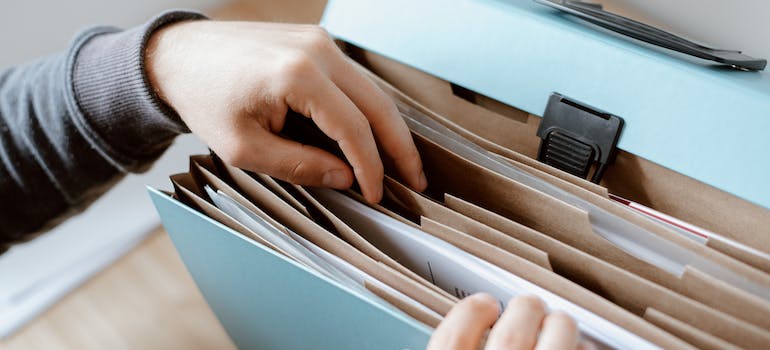 a person going through a bag full of documents