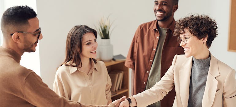 two people shaking hands after closing the deal, which is a final step when you sell your old house in Centreville