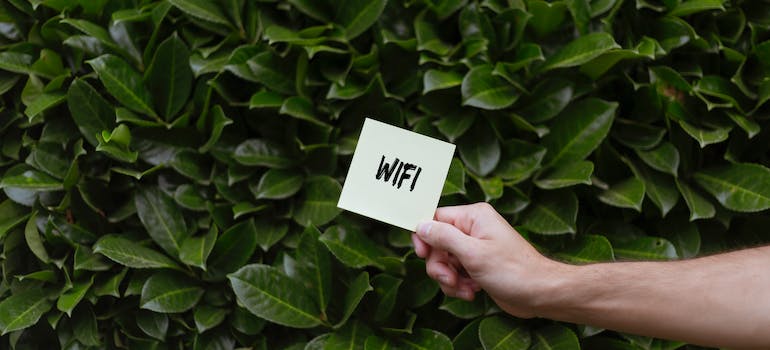 a person holding a card with "WIFI" written on it