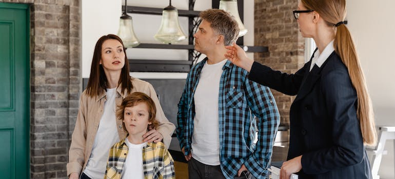 a realtor showing a house to a parents with a single child