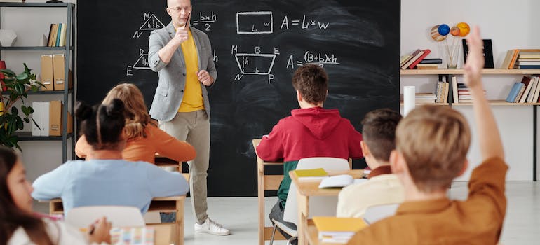 a teacher explaining something to his students in a classroom