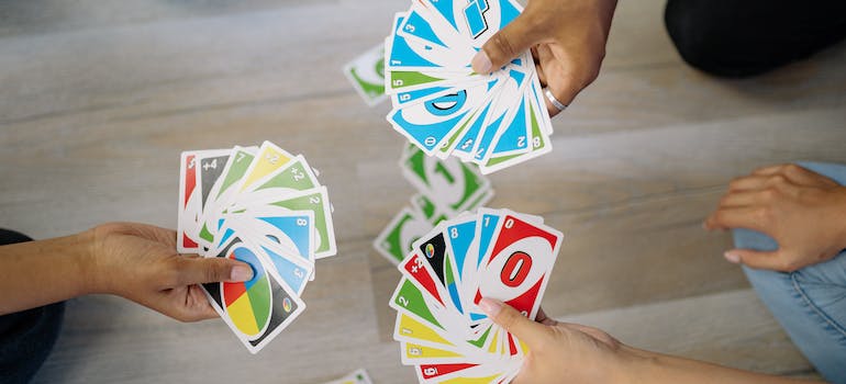 three people playing the game of Uno