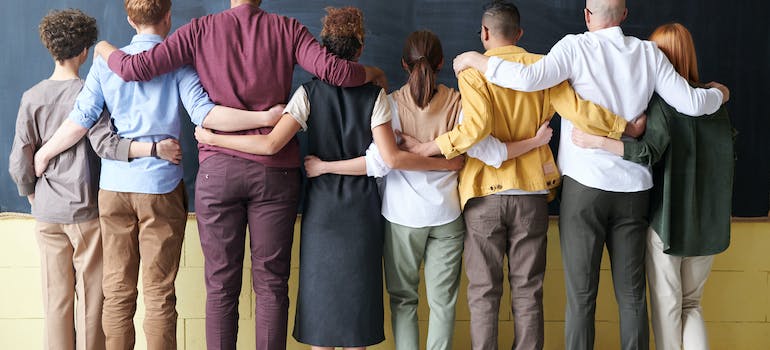 people of different skin, and hair colors standing hugged together