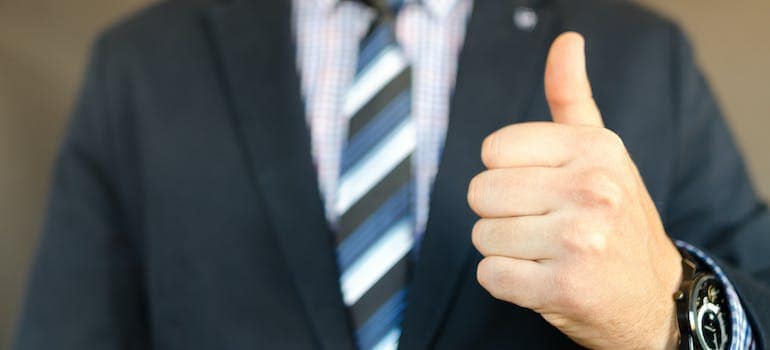 a man in a suit giving a thumbs-up