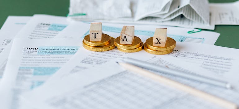 cubes spelling the word "tax" while standing on top of some coins and documents