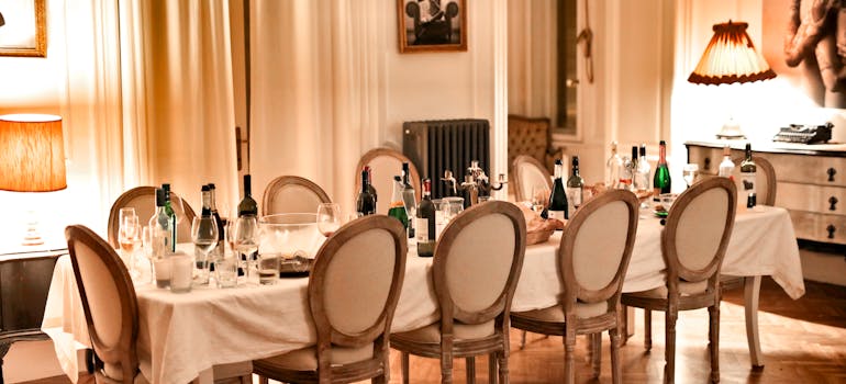 a very long dining room table with lots of glasses and bottles on it