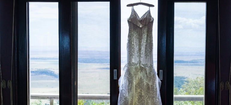 an elegant dress hanging near the window