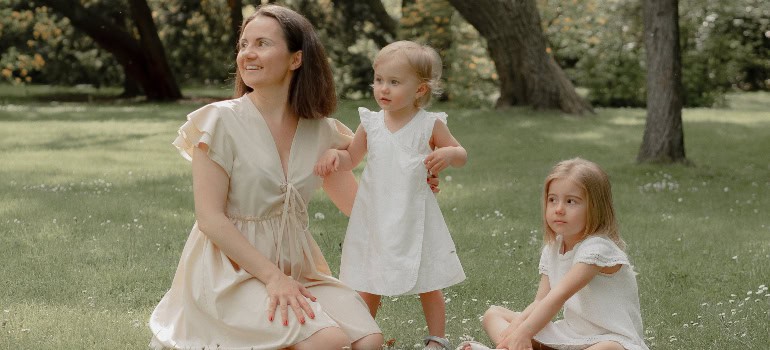 a mother and two daughters are enjoying the nature in the park