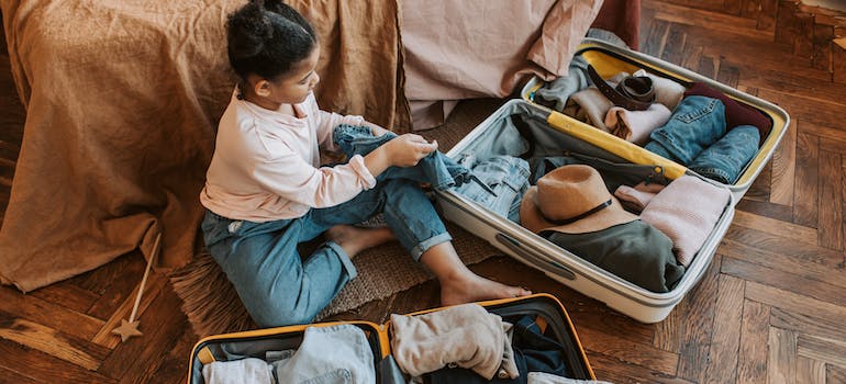 a woman putting clothes into a luggage which is a way to efficiently pack clothes for the move