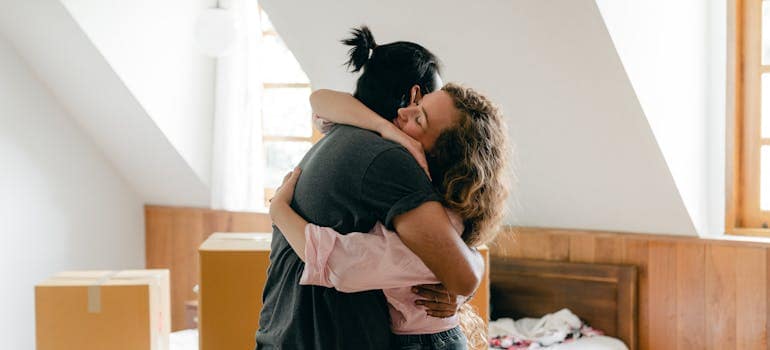 a couple hugging in a room full of boxes