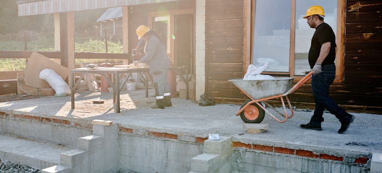 people with hard hats working together to build a house