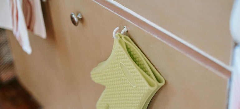 a cabinet knob and a yellow glove hanging next to it