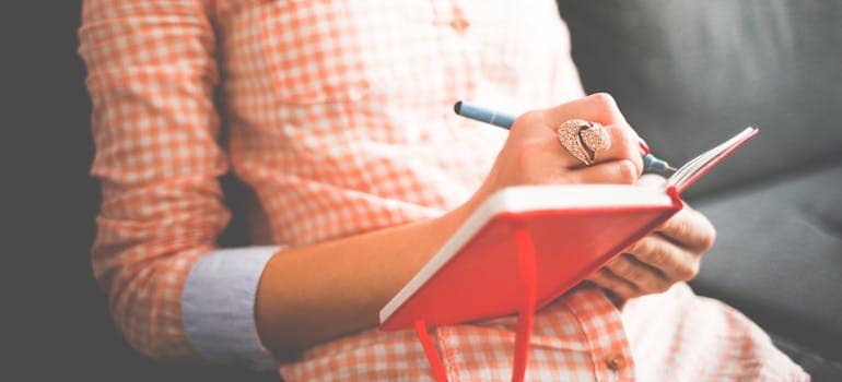 a woman writing something in her journal